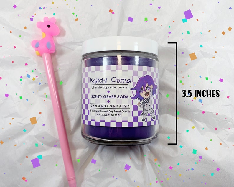 May include: Purple soy candle with a white label featuring an illustration of Kokichi Ouma from Danganronpa V3. The label reads "Kokichi Ouma Ultimate Supreme Leader, SCENT: GRAPE SODA, DANGANRONPA V3, 8oz Hand Poured Soy Blend Candle, ANIMACY STORE". The candle is 8.9 cm tall.