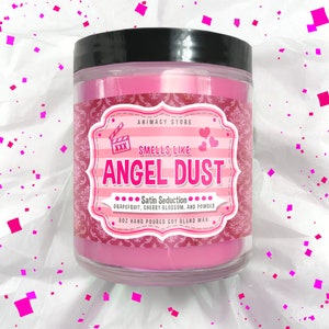May include: Pink glass jar candle with a black lid. The label says "ANIMACY STORE" and "SMELLS LIKE ANGEL DUST... Satin Seduction... Grapefruit, Cherry Blossom, and Powder. 8oz Hand Poured Soy Blend Wax."