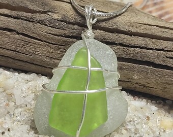 May include: A silver chain necklace with a green and white sea glass pendant wrapped in silver wire.
