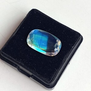 May include: A blue and green iridescent gemstone in a black velvet display box.