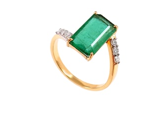 May include: A gold ring with a large emerald green gemstone and smaller diamonds set in the band.
