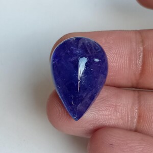 May include: A teardrop-shaped, faceted, blue gemstone with a high polish.