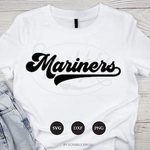 May include: White t-shirt with the word "Mariners" in a black, retro script across the front. Below the text are three black circles with the letters SVG, DXF, and PNG. The words "BY SCRIBBLE BRUSH" are at the bottom.
