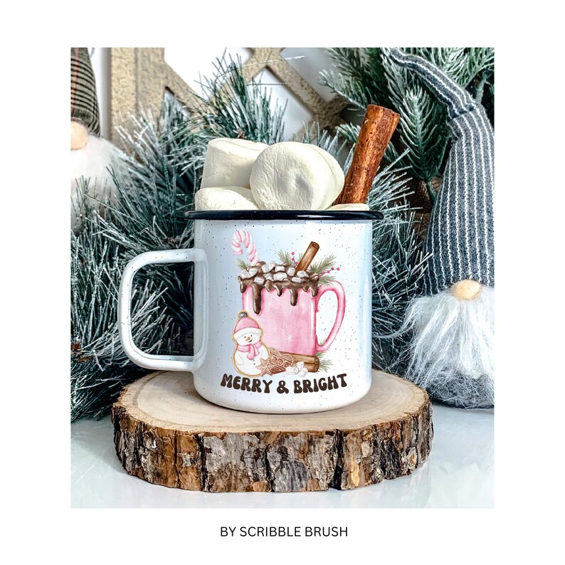 May include: White enamel mug with a pink and brown illustration of a snowman holding a candy cane and a mug of hot chocolate with marshmallows. The mug has the text "Merry & Bright" on the front.