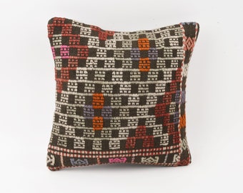 May include: A brown, white, orange, pink, and purple patterned throw pillow with a geometric design.