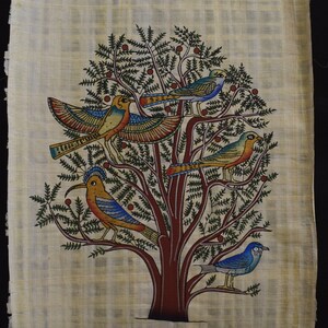 Può includere: Un rotolo di papiro dipinto a mano che rappresenta un albero stilizzato con cinque uccelli. L'albero ha un tronco marrone e foglie verdi con bacche rosse. Gli uccelli sono dipinti in vari colori, tra cui blu, giallo e rosso.