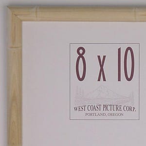 May include: A rectangular wooden picture frame with a light wood finish. The frame holds an 8 x 10 inch print. The text "8 x 10" is printed in a dark color, along with the text "WEST COAST PICTURE CORP. PORTLAND, OREGON".