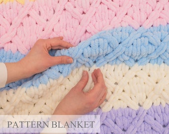 May include: A chunky knit blanket featuring horizontal stripes in pastel yellow, pink, light blue, cream, and lavender. The yarn has a soft, plush texture with a repeating crisscross pattern. The text "PATTERN BLANKET" is visible on the image.