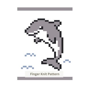 Op de afbeelding: Een pixel art illustratie van een springende grijze en witte dolfijn, geplaatst boven kleine lichtblauwe golficonen. De tekst "Finger Knit Pattern" staat in een grijs lettertype onderaan in het midden, omlijst door twee grijze balken.