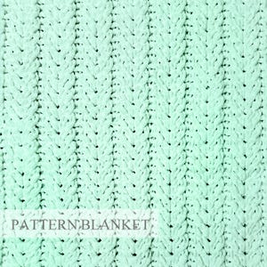 Op de afbeelding: Een mintgroene gebreide deken met een verticaal kabelpatroon. De stof heeft een dikke, getextureerde uitstraling met herhalende kolommen van gevlochten lussen. De tekst "PATTERN BLANKET" is in een donker lettertype onderaan gedrukt.