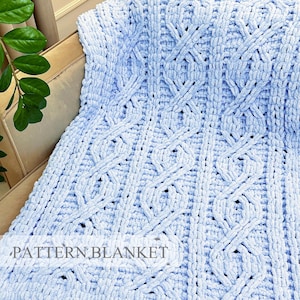 Puede incluir: Una manta de punto grueso en color azul claro con un patrón de trenzas repetitivo. El hilo suave y texturizado crea una superficie gruesa y afelpada con columnas verticales de bucles entrelazados. El texto PATTERN BLANKET es visible abajo.
