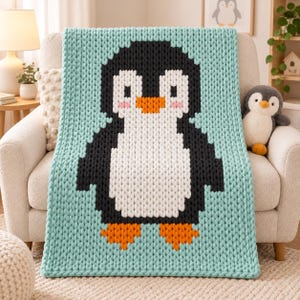 Puede incluir: Una manta de punto grueso con un gran diseño de pingüino pixelado. El pingüino es negro, blanco y naranja con mejillas rosadas, centrado sobre un fondo verde menta claro. La manta tiene una construcción de hilo grueso y texturizado.