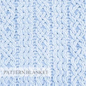 Puede incluir: Una manta de punto grueso en color azul claro con un patrón repetitivo de trenzas y costillas verticales. La tela tiene una apariencia suave y afelpada con bucles de hilo gruesos. El texto "PATTERN BLANKET" aparece en gris oscuro.