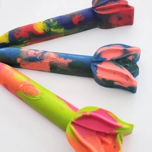May include: Three colorful crayon pencils with a flower-shaped tip. The crayons are green, blue, and red with swirls of different colors. The crayons are labeled "Crayola".