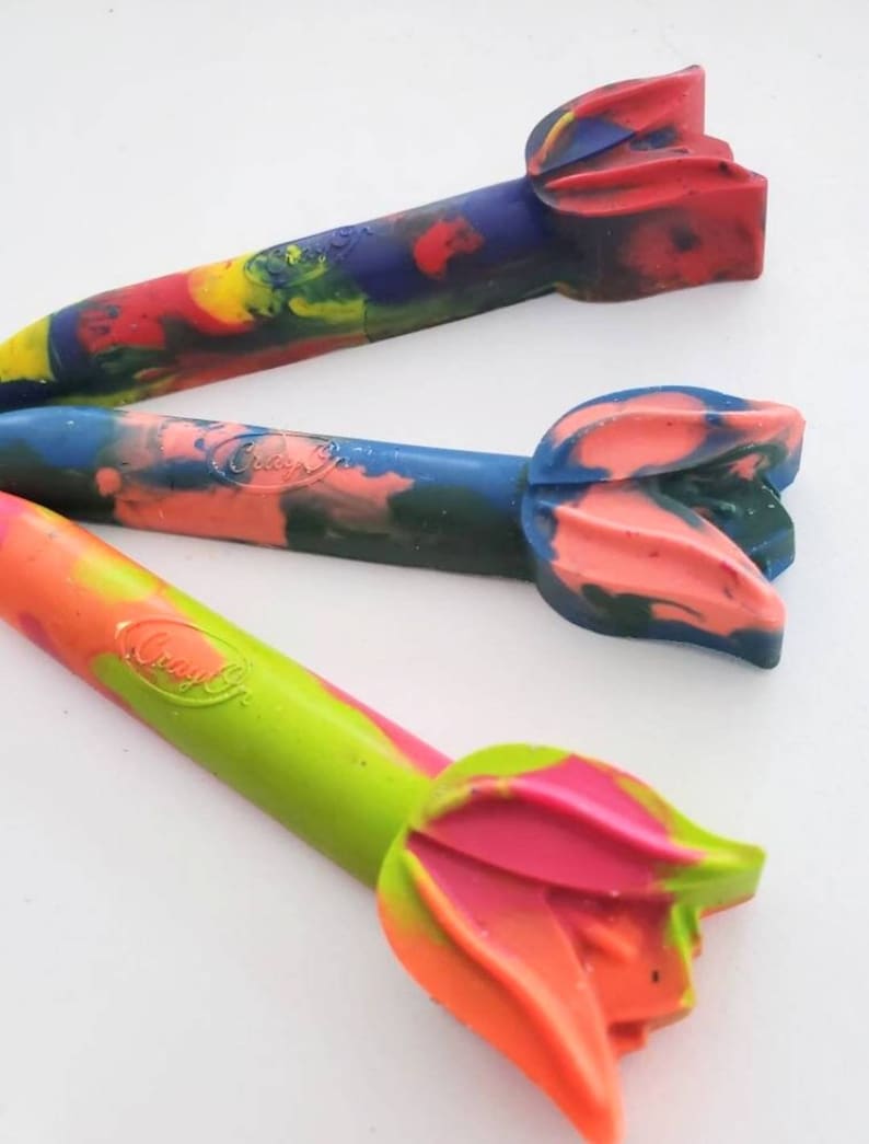May include: Three colorful crayon pencils with a flower-shaped tip. The crayons are green, blue, and red with swirls of different colors. The crayons are labeled "Crayola".