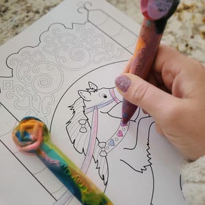 May include: A close-up of a coloring page featuring a cartoon horse on a carousel. The horse is being colored in with a rainbow crayon and a pink and purple crayon. The text "Crayola" is visible on the rainbow crayon.