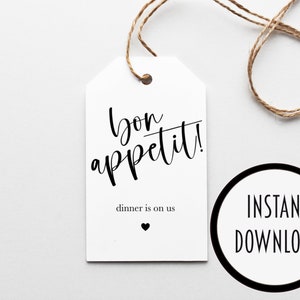 Peut inclure: Une étiquette cadeau imprimable blanche avec du texte noir qui dit "bon appétit!" et "dîner est à nous" avec un petit cœur noir. L'étiquette est attachée avec de la ficelle.