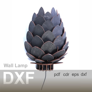 Op de afbeelding: Een zwarte houten wandlamp in de vorm van een dennenappel. De lamp heeft een snoer en een stekker. De tekst "Wall Lamp DXF pdf cdr eps dxf" is zichtbaar onderaan de afbeelding.