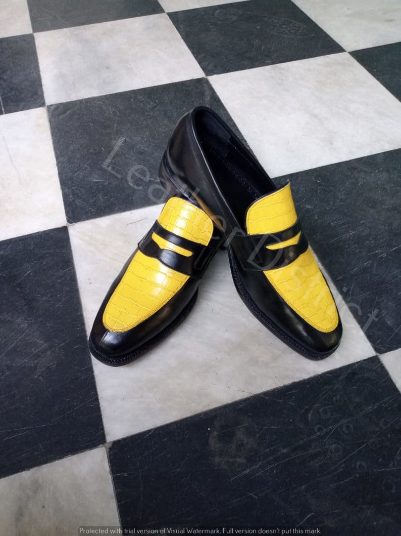 May include: A pair of black leather loafers with yellow leather accents. The loafers have a pointed toe and a slip-on design.