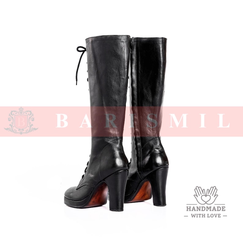 May include: A pair of black leather knee-high boots with lace-up detailing and high heels. The boots have a platform sole and a polished finish, with a wooden-look heel. The boots are displayed against a white background.