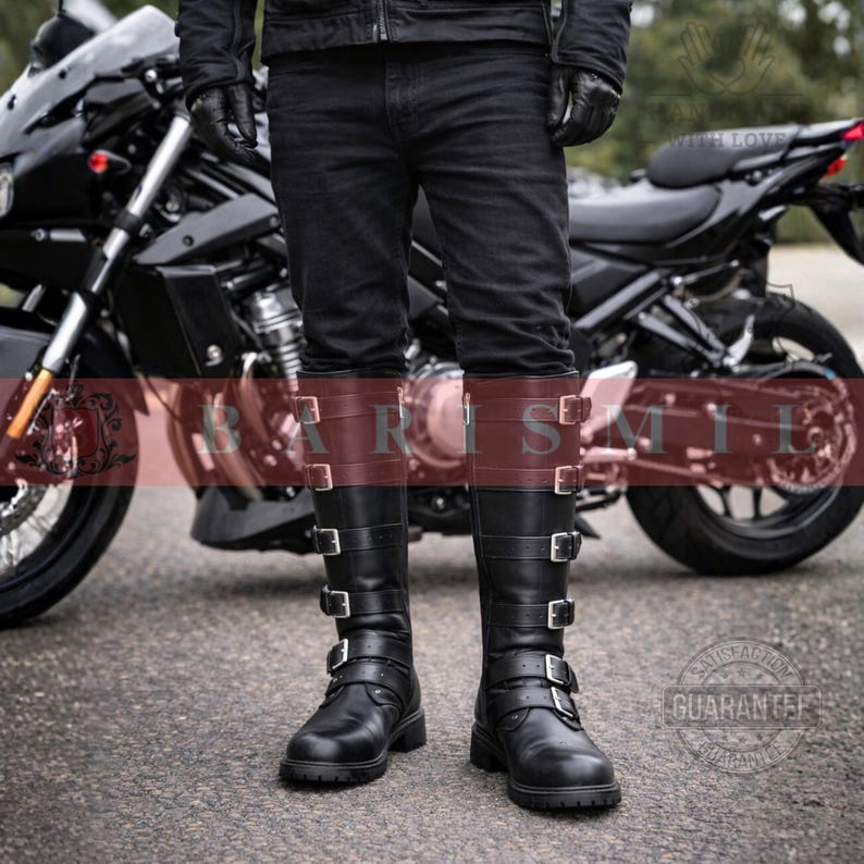 May include: Black leather knee-high boots with multiple silver buckles. The boots have a brown leather band at the top. The boots are worn with black jeans. A black motorcycle is in the background.