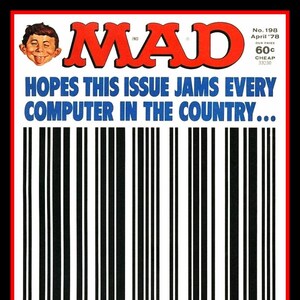 May include: A vintage MAD magazine cover with a red and white logo and the text "MAD" in large, bold letters. The cover features a cartoon character with a mischievous expression and the text "HOPES THIS ISSUE JAMS EVERY COMPUTER IN THE COUNTRY..." in blue letters. A black and white barcode is printed below the text with the number "70989 33230" printed below the barcode. The text "...FOR FORCING US TO DEFACE OUR COVERS WITH THIS YECCHY UPC SYMBOL FROM NOW ON" is printed in red and yellow letters at the bottom of the cover.