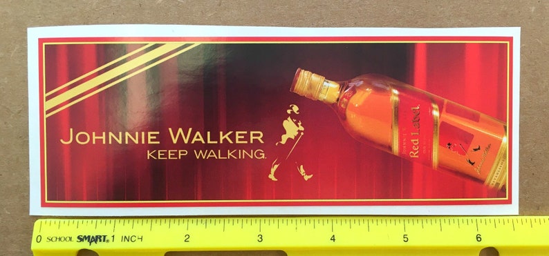 May include: A red and gold Johnnie Walker Red Label whiskey bottle with the slogan "Keep Walking" on a red background.