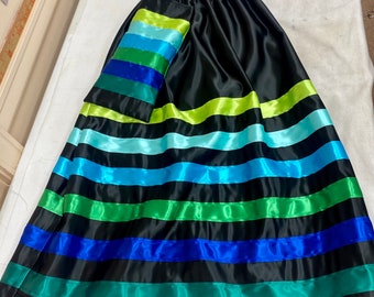 May include: A black satin skirt with green, blue, and light blue satin ribbon stripes. The skirt has a matching pocket on the side.