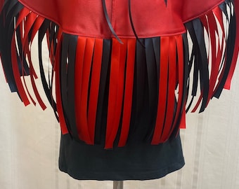 May include: A red and black fringe trim with a black fabric base. The fringe is made of alternating red and black ribbon.