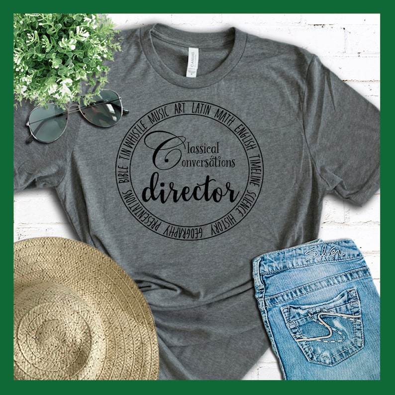Puede incluir: Camiseta gris con un dise&ntilde;o circular negro que dice "Classical Conversations director" rodeado de las palabras "Bible, Tin Whistle, Music, Art, Latin, Math, English, Timeline, Science, History, Geography, Presentations".