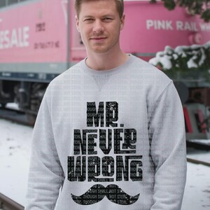 May include: A light gray sweatshirt with the text "MR. NEVER WRONG" in black, along with a black mustache graphic. The background features a pink train and the words "THOUGH SHALL NOT STEAL" in a repeating pattern.