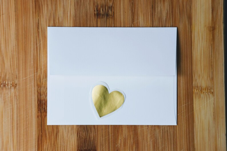 May include: A white envelope with a gold heart sticker on the front.