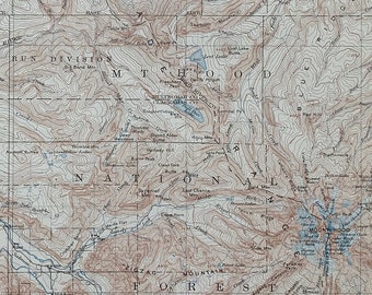 May include: A vintage topographic map of Mount Hood and vicinity, Oregon. The map shows the surrounding area, including the Columbia River, forest, and elevation contours. The map is printed on paper and has a brown and blue color scheme.