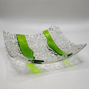 May include: A clear glass serving dish with a textured surface and two green stripes.