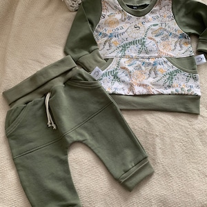 6-9 month set, olive green French knit sweater, dinosaur patterns, adjustable jogging pants with pockets. Made in Quebec