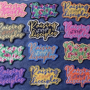 May include: Twelve embroidered patches with the text "Raising Tiny Disciples" in various colors and designs. The patches are arranged in a grid on a blue denim background.