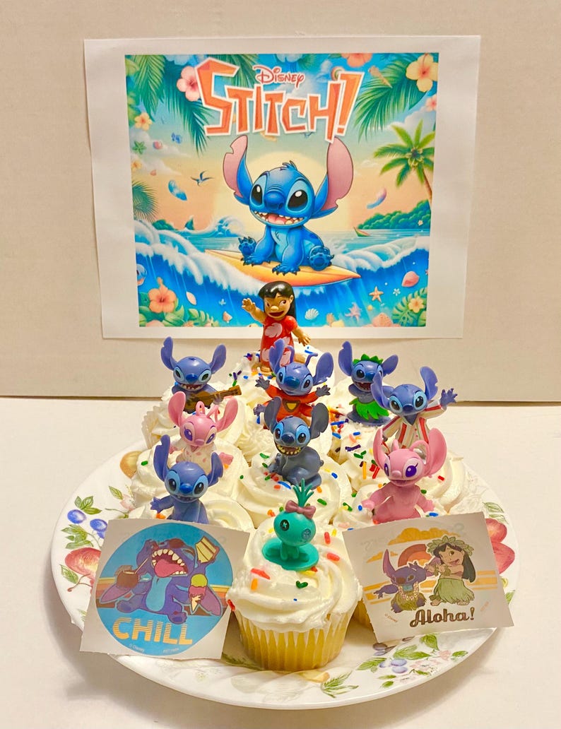 May include: A plate of cupcakes decorated with Stitch characters from the Disney movie Lilo & Stitch. The cupcakes have blue, pink, and green frosting and are topped with sprinkles. There are also edible images of Stitch on the cupcakes. The cupcakes are on a white plate with a floral pattern. There is a poster of Stitch surfing in the background.