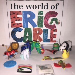 May include: A collection of Eric Carle The Very Hungry Caterpillar toys and stickers. The set includes a caterpillar, a butterfly, a ladybug, a panda, a frog, a lion, a horse, a polar bear, a duck, and a sticker sheet with a rainbow and a chameleon. The set also includes a blue coin with a butterfly design.