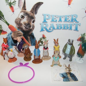 May include: A set of 10 Peter Rabbit character figurines, including Peter Rabbit, Benjamin Bunny, Mr. McGregor, and more. The figurines are made of plastic and are about 2 inches tall. The set also includes a purple headband and a sticker sheet featuring Peter Rabbit.