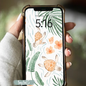 Op de afbeelding: Een telefoonscherm met een digitale klok die 5:16 laat zien met de datum woensdag 11 maart. De achtergrond is een aquarelontwerp van groene palmbladeren, oranje bloemen en twee oranje zeeschildpadden die in blauw water zwemmen.