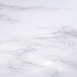 Może przedstawiać: Białe marmurowe tło z gładką, polerowaną powierzchnią i subtelnym wzorem żyłek.