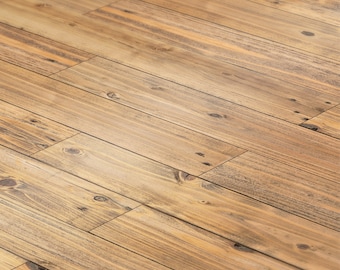 May include: A close-up of a light brown wood floor with a diagonal pattern. The wood has a natural grain and a slightly distressed look.