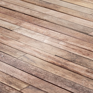 以下が含まれることがあります： 斜めに並んだ木製の床のクローズアップ。木は薄い茶色で、自然な木目があります。