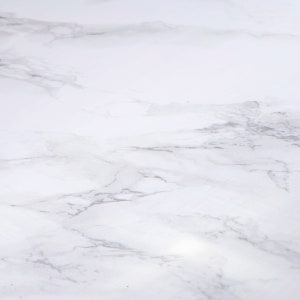 Peut inclure: Gros plan sur une surface en marbre blanc avec des veines grises. Le marbre a un aspect poli, avec de subtiles variations de tons et de textures. L'effet global est propre et élégant.