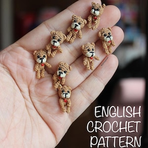 May include: A selection of tiny, crocheted teddy bears. Each bear is brown with black eyes and a red heart-shaped detail. The image includes the text "ENGLISH CROCHET PATTERN".