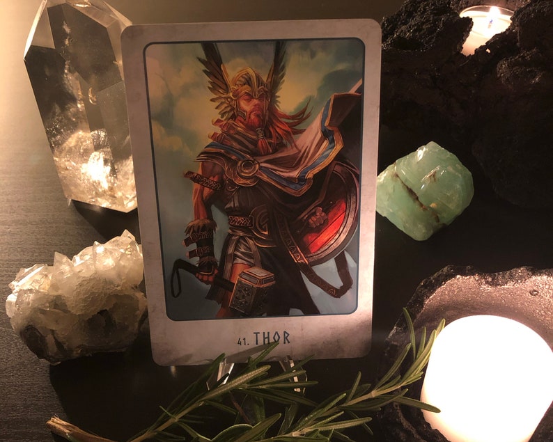 Peut inclure: Une carte de tarot repr&eacute;sentant Thor, un dieu nordique, tenant un marteau et un bouclier. La carte est num&eacute;rot&eacute;e 41 et le mot "THOR" est imprim&eacute; sous l'image.