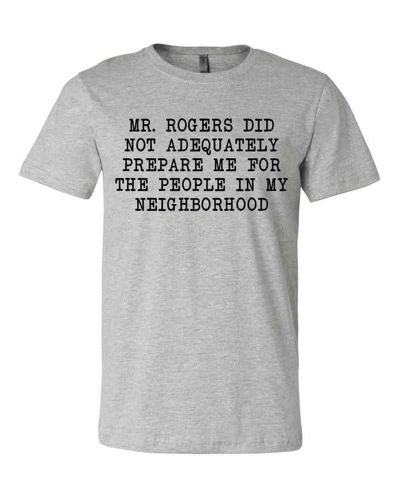 May include: Gray t-shirt with black text that reads "Mr. Rogers did not adequately prepare me for the people in my neighborhood."