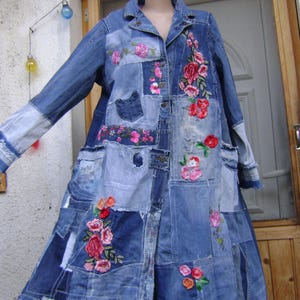 May include: A patchwork denim coat with floral embroidery. The coat is made from various shades of blue denim, sewn together in a patchwork design. Red, pink, and orange embroidered flowers are scattered across the coat, adding a touch of color and detail.
