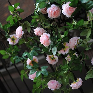 Könnte beinhalten: Eine Girlande aus künstlichen rosa Rosen mit grünen Blättern, perfekt, um jedem Raum einen Hauch von Eleganz zu verleihen.