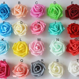 May include: Assortment of 20 artificial foam roses in various colours, including light blue, peach, pink, green, red, white, yellow, and grey. The roses are arranged in rows labelled with letters A through T.